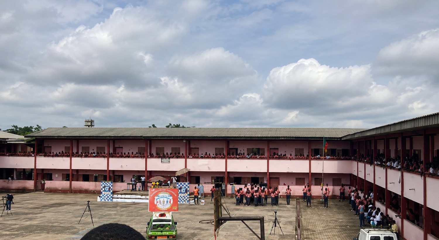 Cérémonie dans la cour du Collège BAHO, élèves rassemblés aux balcons
